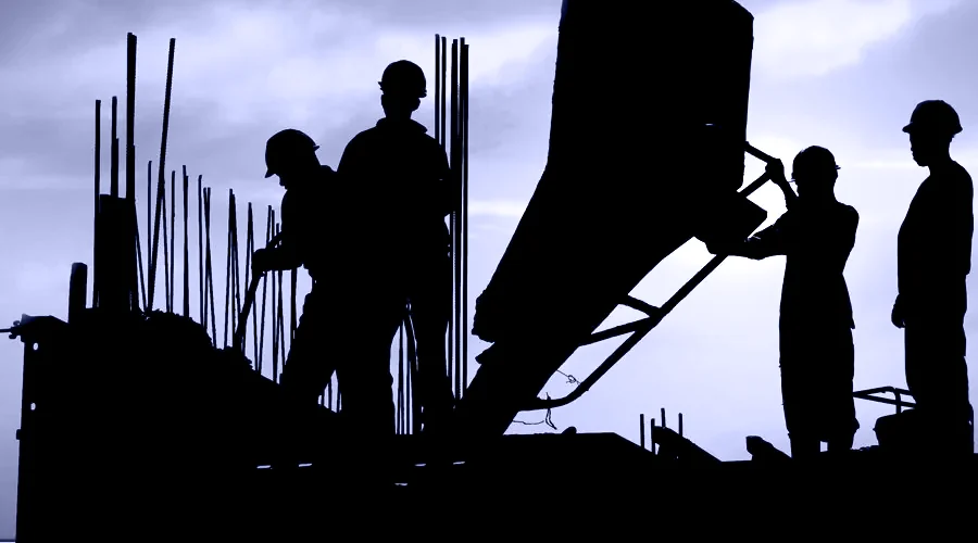 A site crew placing concrete at sunset
